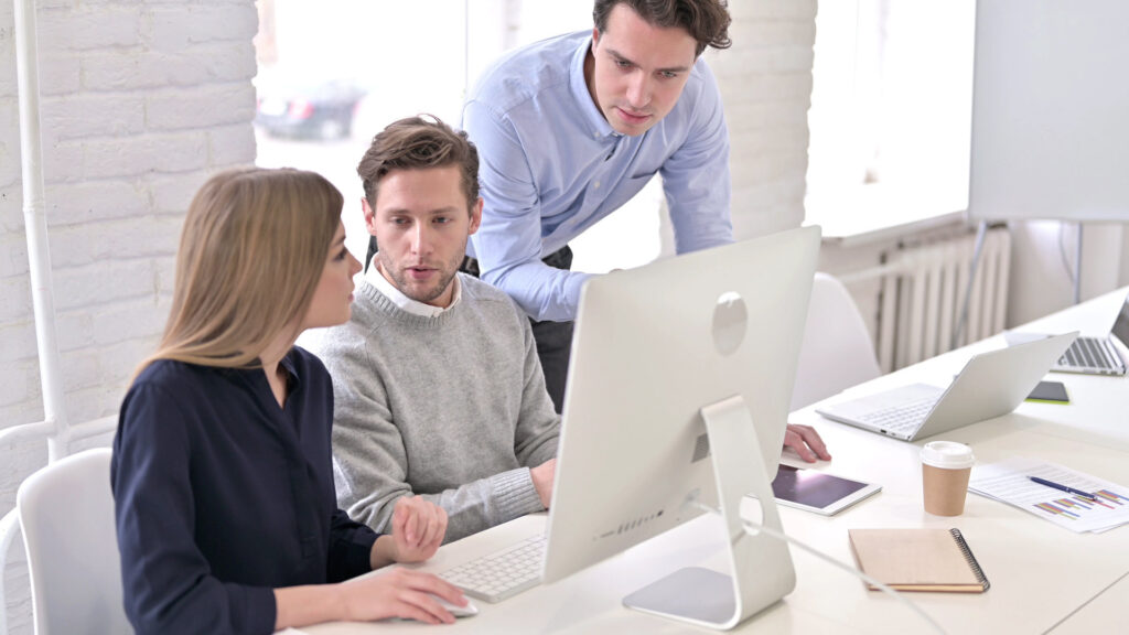 Angry Man Discussing with Team and using Desktop